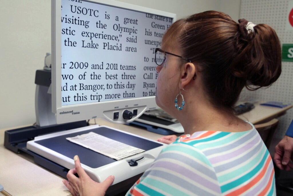 Picture of a client with vision loss at a CCTV magnifier