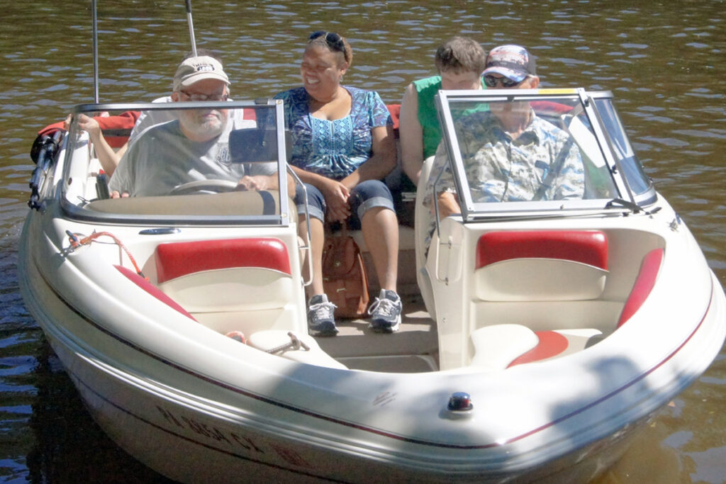 Photo of two Sights for Hope clients and two Lions Club members in boat