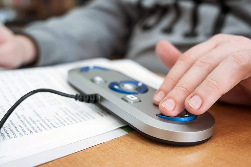 Photo of a young man's hand use a small scanner and reader on a book