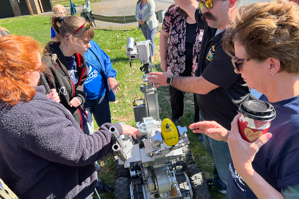 Two Sights for Hope campers checking out the Allentown Fire Department Bomb Squad's robot. With them are a member of the bomb squad and a Sights for Hope staff member