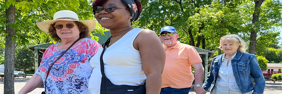 Four happy clients walking outdoors in a park